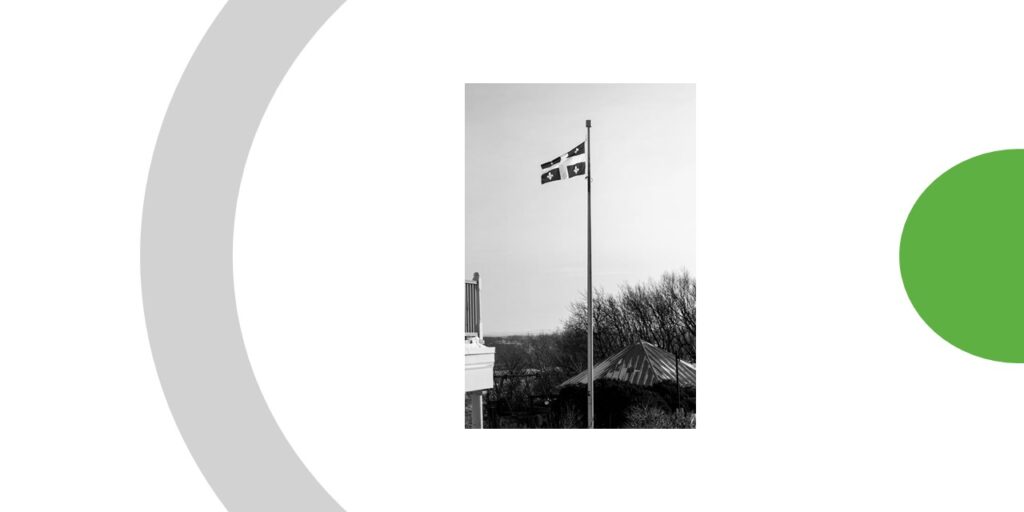 Drapeau du Québec (bleu et blanc) hissé tout haut vers le ciel.