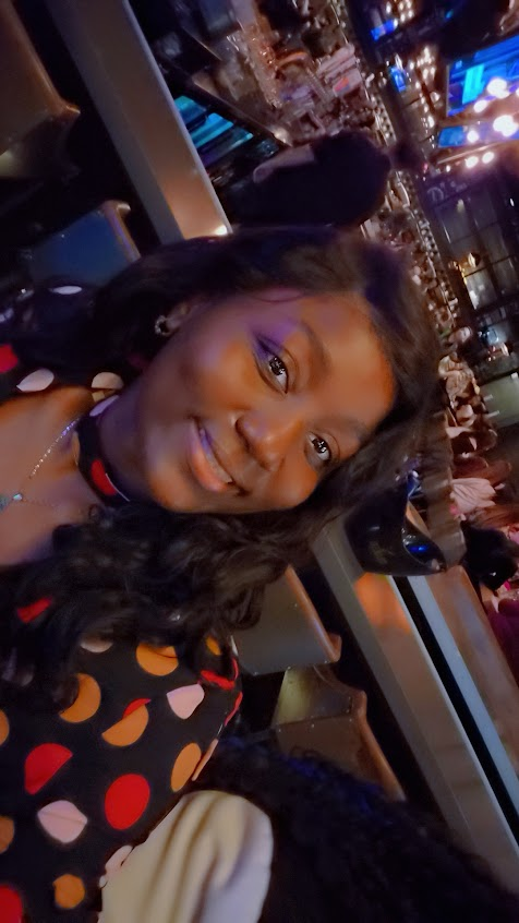 jeune fille souriante, habillée d'un vêtement coloré.
